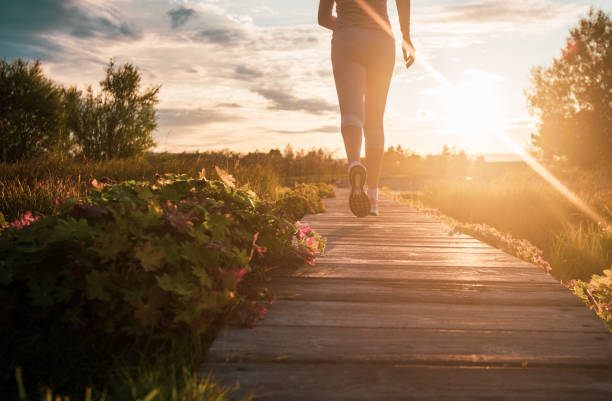 Close up of unknown woman running in park at sunset Central Florida Lifestyle self-care highlighted in sunset walk