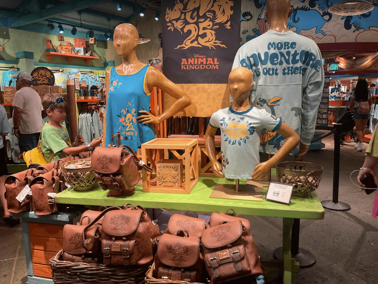 Screenshot2023042415904PM Central Florida Lifestyle Disney's Animal Kingdom 25th Anniversary merch shirts bags green table gift shop