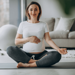 Young pregnant woman practicing yoga at home