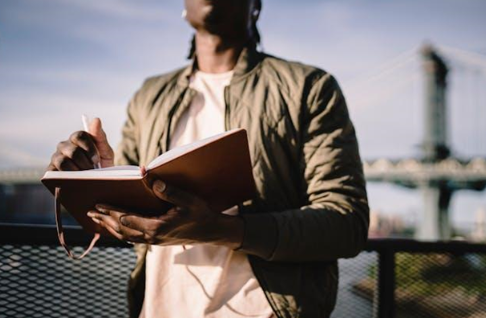 A man holding a notebook and a pen 