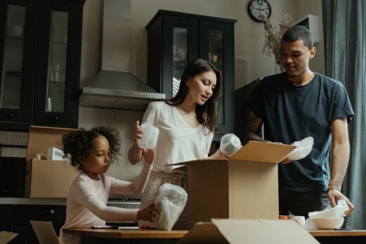 Family unpacking boxes in a new Central Florida home with palm trees visible outside