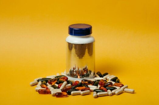 A variety of dietary supplement bottles and capsules on a counter